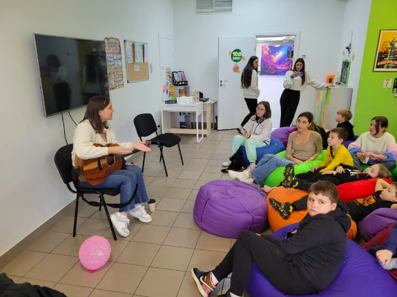 Sam playing the guitar for school kids in Kyiv.